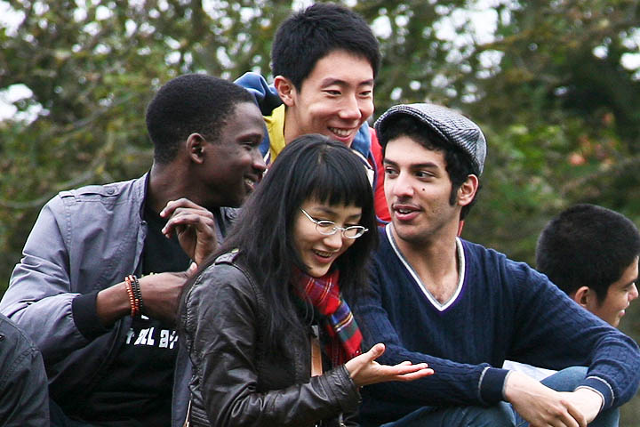 Group of four students from different countries chatting to each other