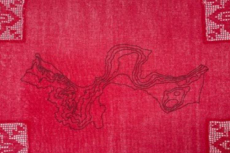 Red cloth with an abstract embroidered pattern, also in red, upon it.