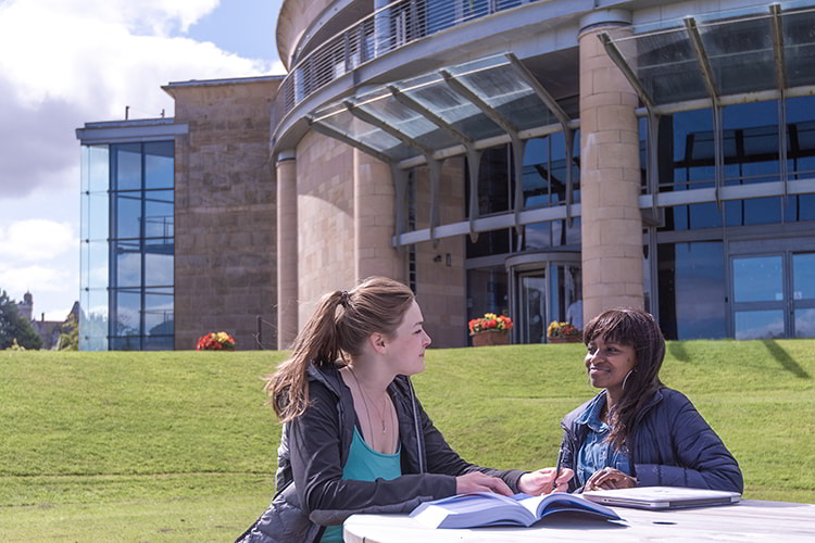 Two Management students sitting in front of the Gateway