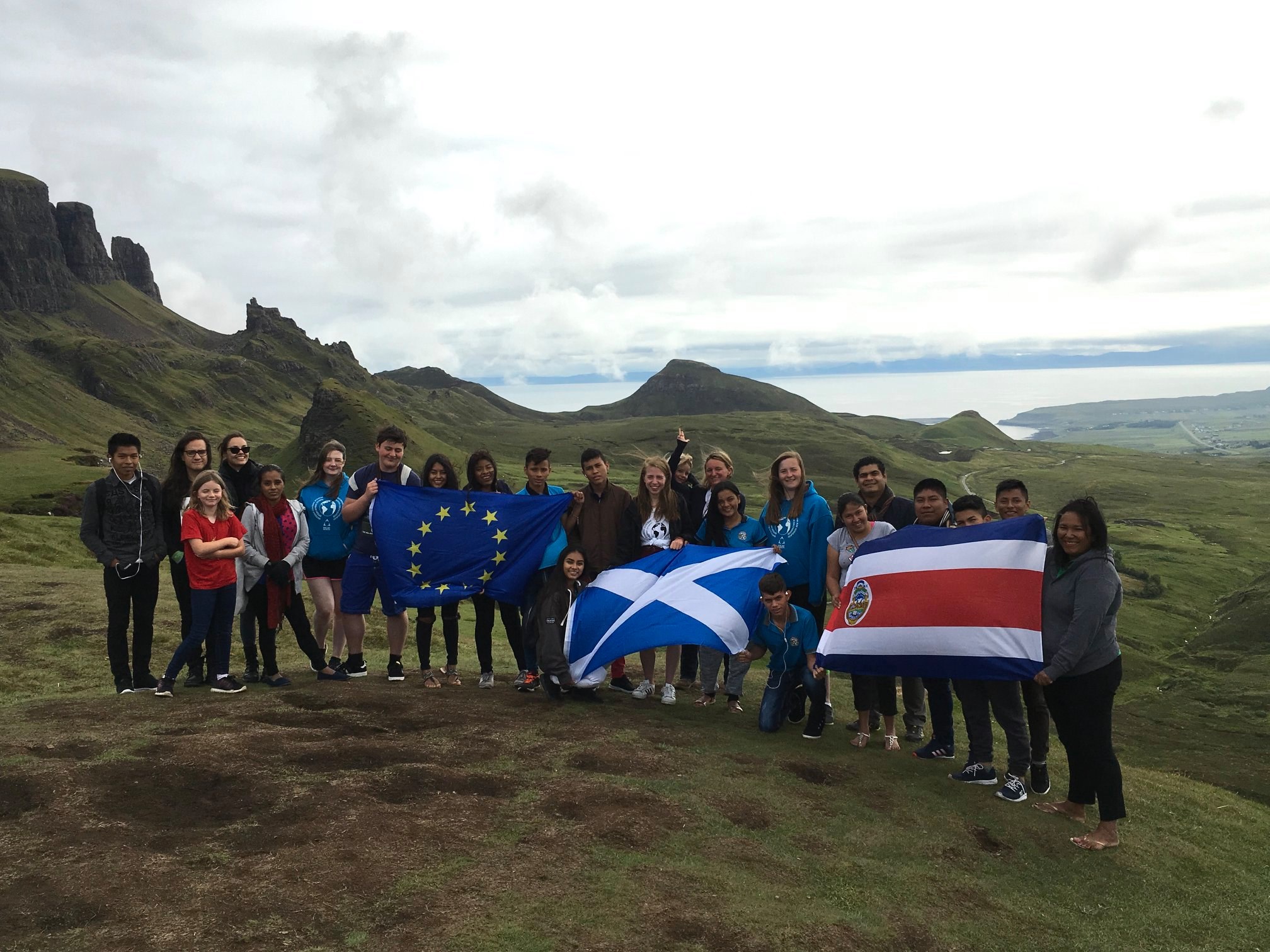 Participants from the Bi-Regional Youth Exchange on the Isle of Skye, July 2018, holding flags of Scotland, Costa Rica and the European Union