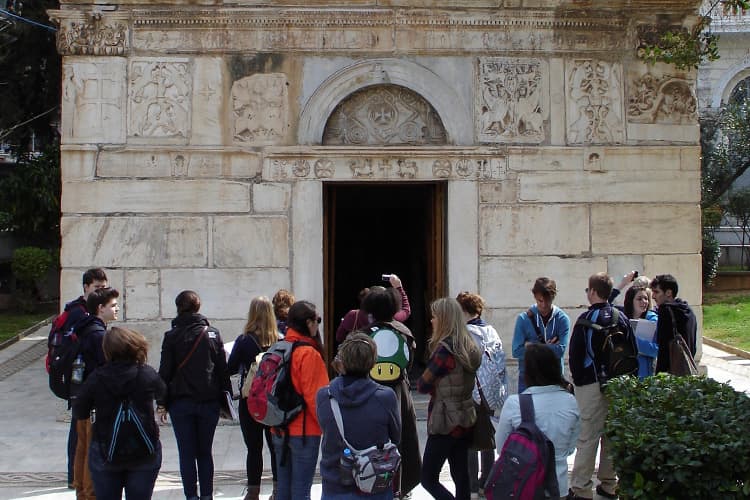 People looking at beige stone-carved building