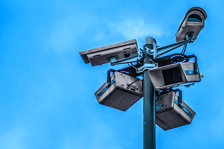 security cameras on a pole against a blue sky. by nathy dog on unsplash