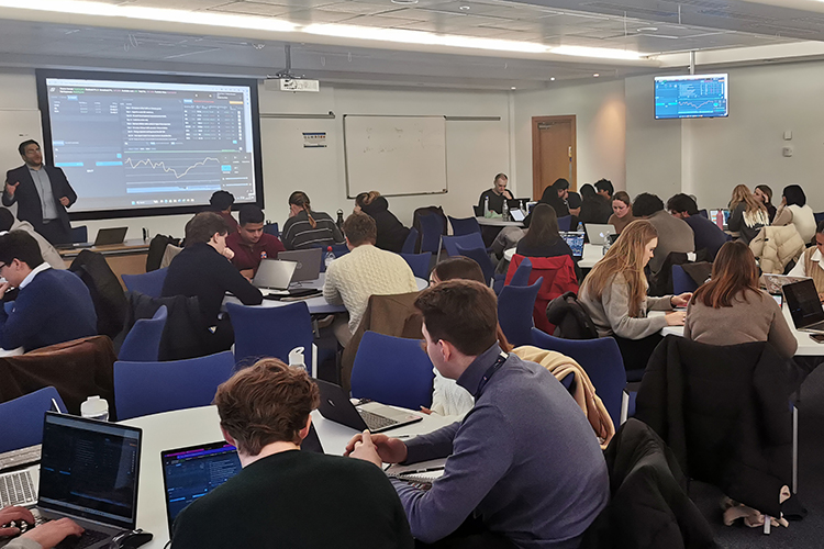 students in a room with academic showing a presentation