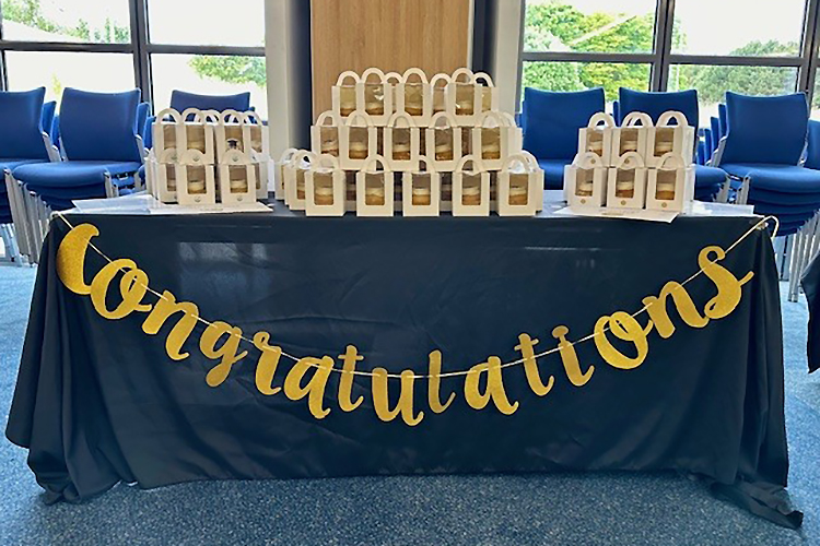 tacle with boxes of cupcakes on top and 'Congratulations' banner