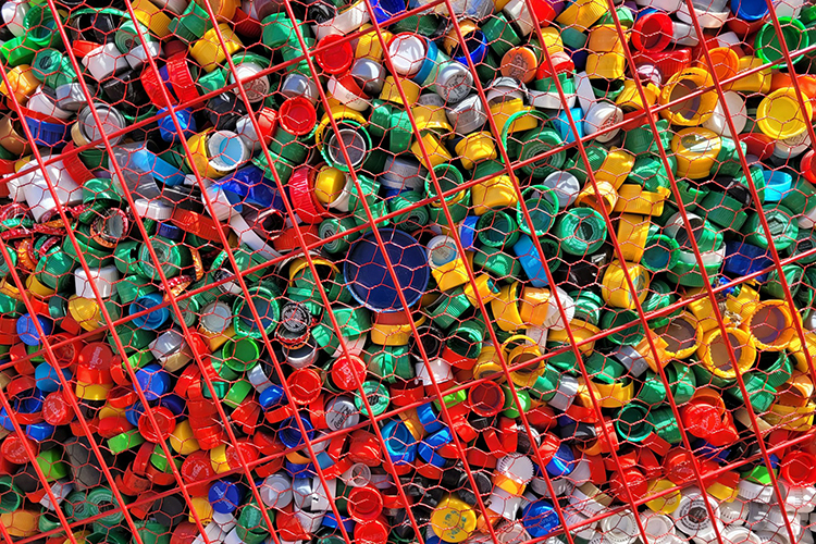 large amount of plastic bottle caps in a cage, credit Killari Hotaru on unsplash