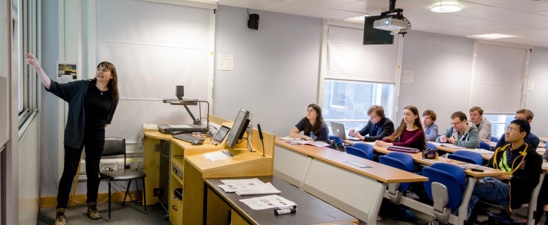 Tutor explaining material to students at a tutorial.