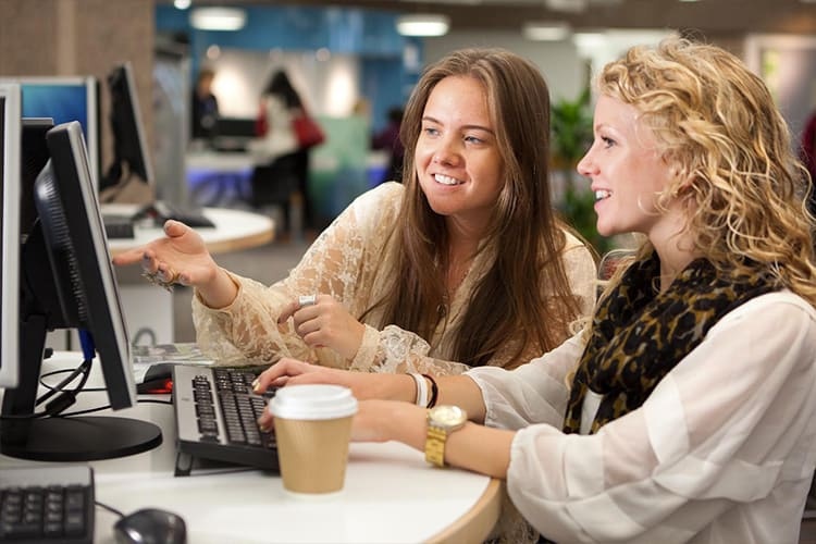 Illustrative photo of two people working at a computer.