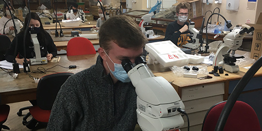 student using microscope