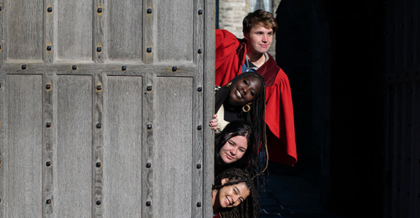 students hiding behind door