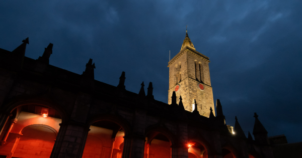 building and church tower at night with red lighting