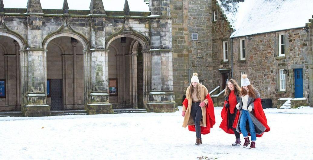 Three students in the snow with woolly hats