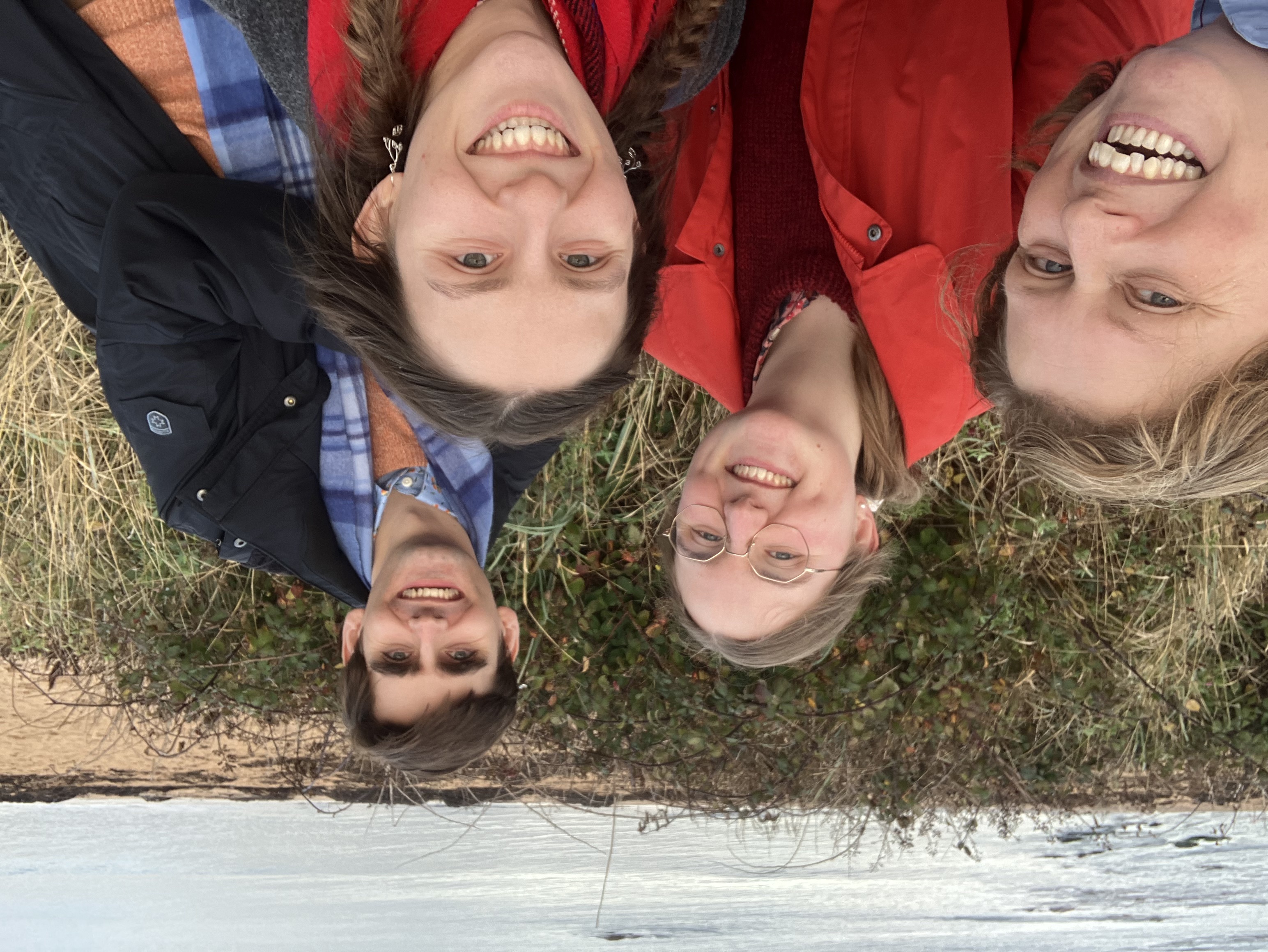 Four people smiling with the sea of North Berwick behind.